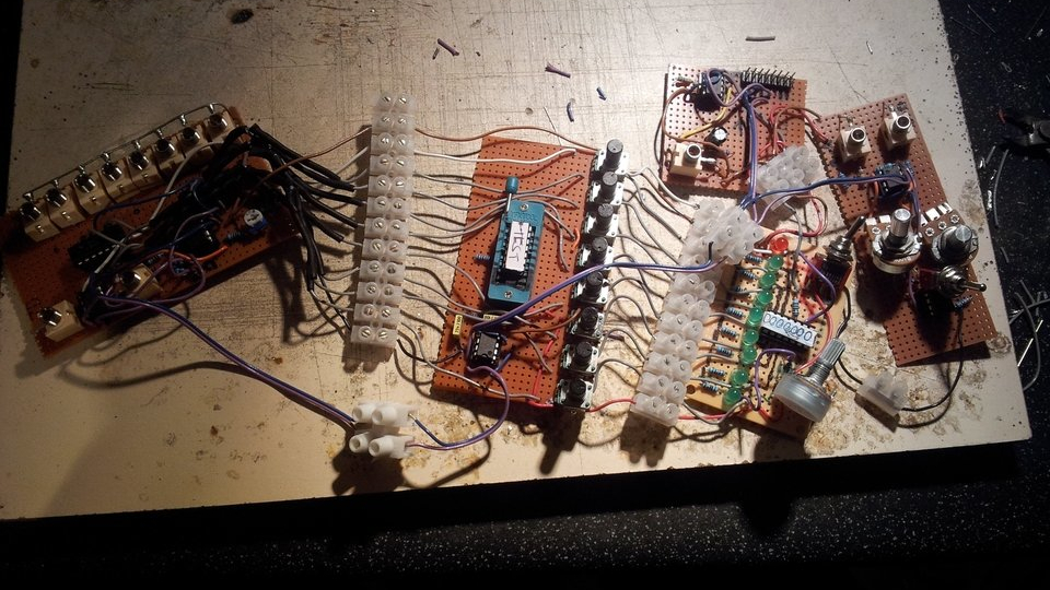 A messy circuit made from many hand made circuit boards connected by wires.